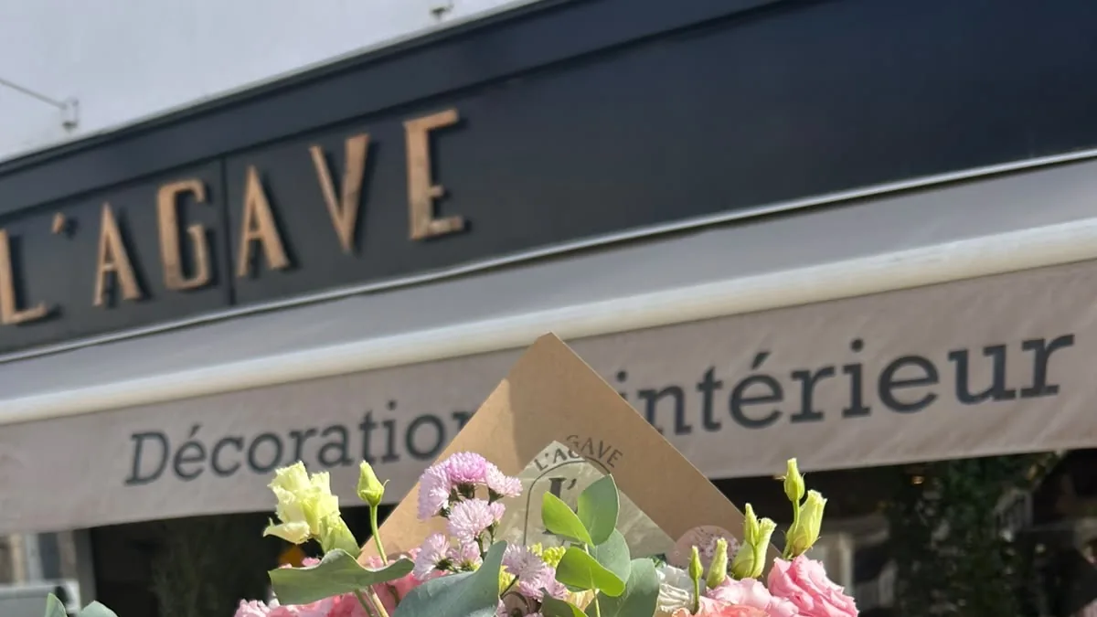 L’enseigne noire aux lettres de bronze de L’AGAVE et son store « Décoration d’intérieur »